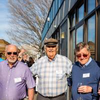 Group of five event attendees standing outside at event, smiling at camera